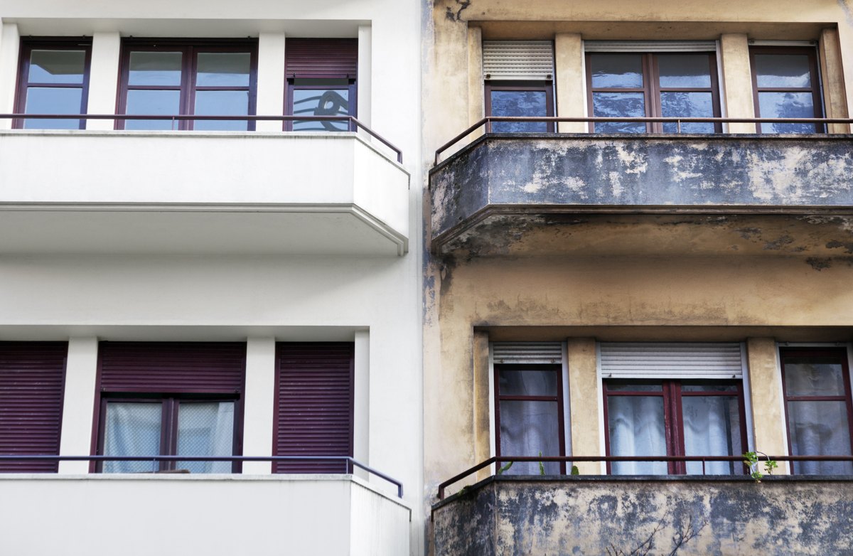 Symbolischer Vergleich einer modernisierten und einer unsanierten Hausfassade